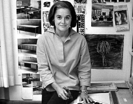 Portrait of American architect and furniture designer Florence Knoll Bassett as she sits on the edge of a table with a book of fabric swatches in front of her, 1961.  Image: Ray Fisher/The LIFE Images Collection, Getty Images.